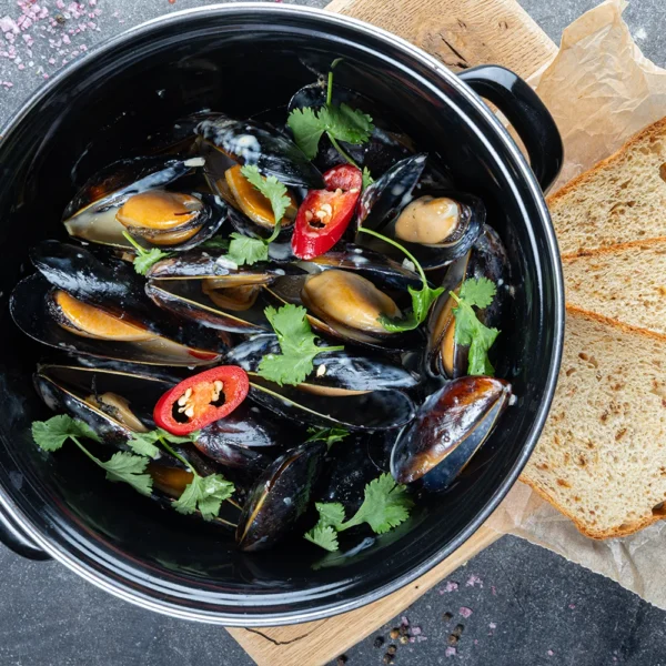 Mussels (1 kg) in garlic-chili sauce with white wine and spicy herbs, onion bun